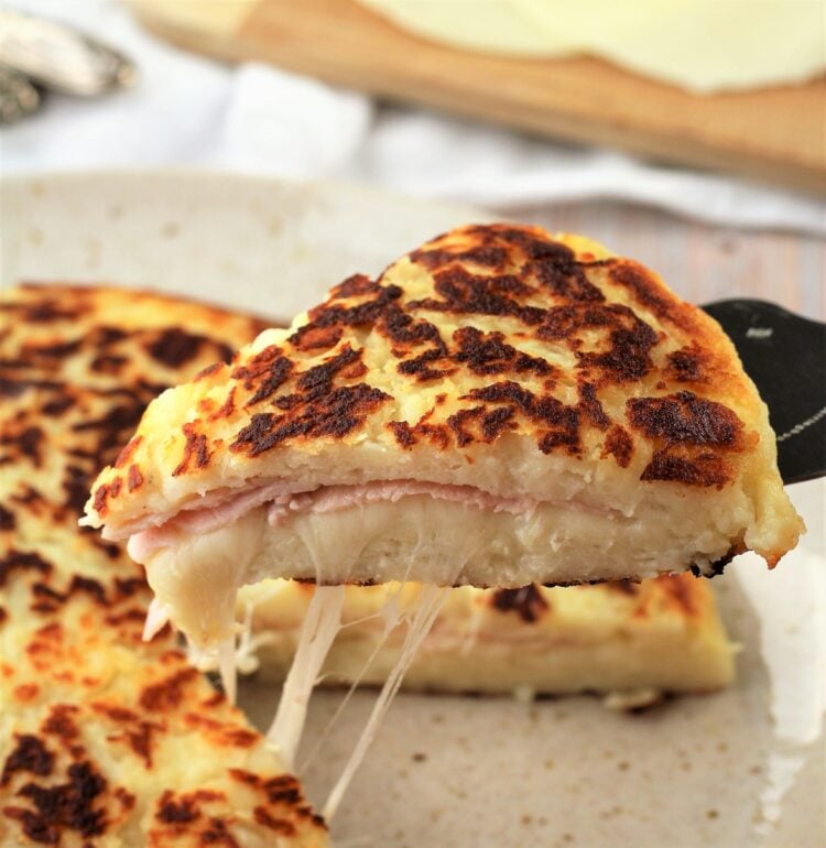Wedge of skillet potato focaccia with ham and cheese.