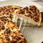 Ham and cheese potato focaccia wedge served with spatula.