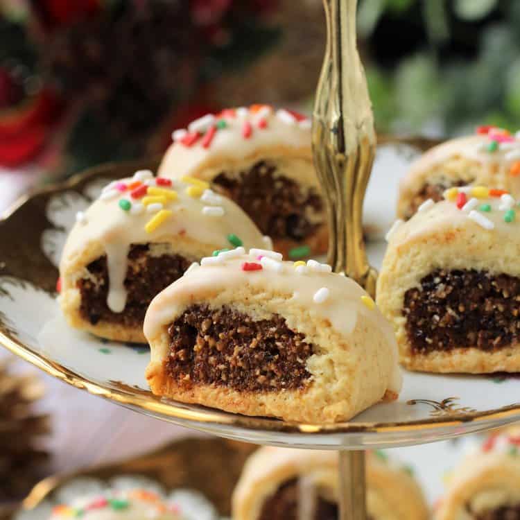 Cuccidati fig cookies on tiered plate.