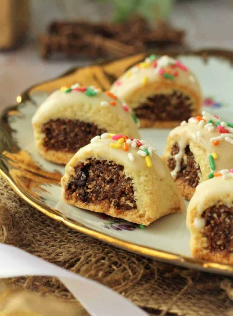 Cuccidati cookies filled with figs on plate.