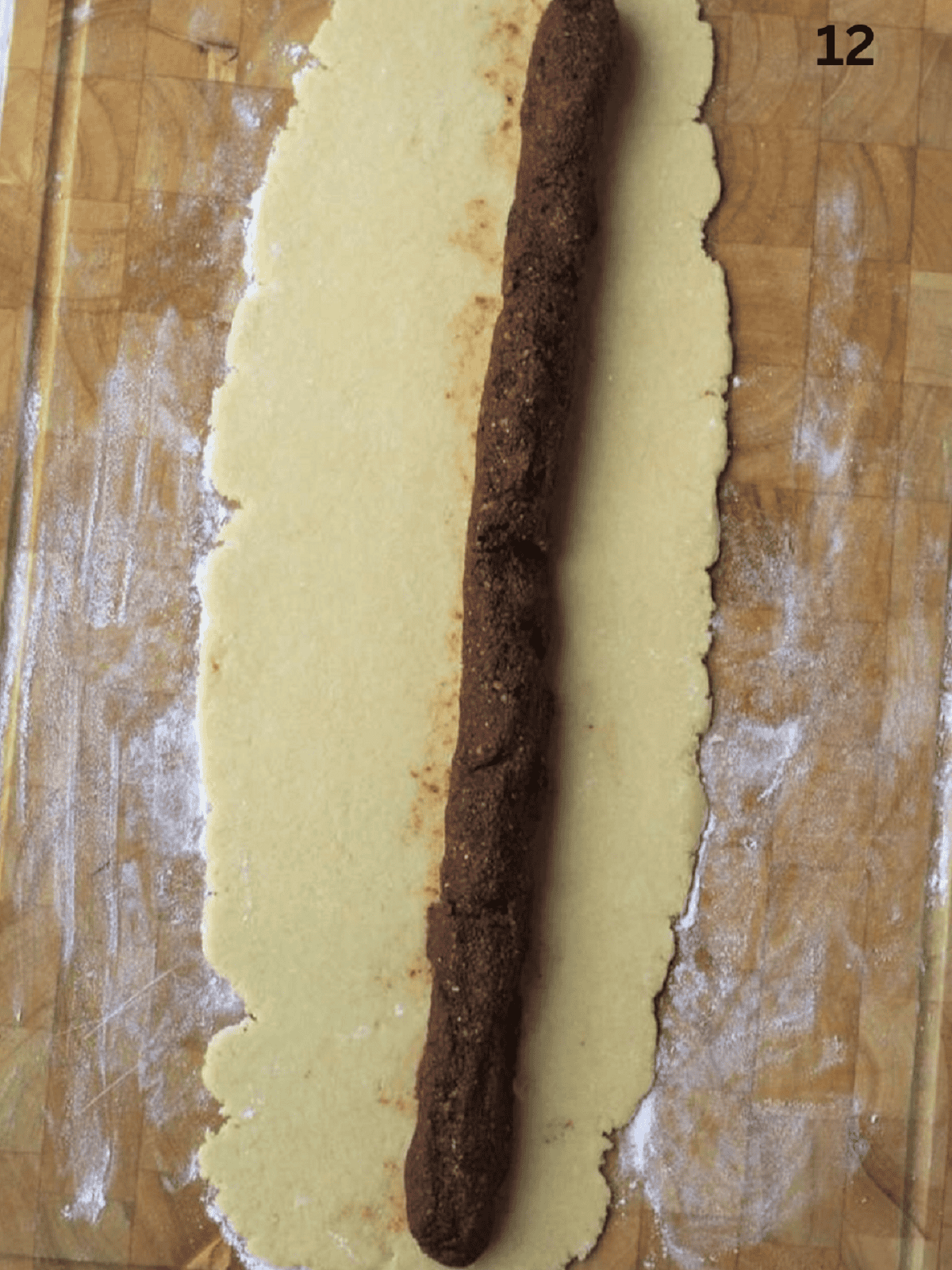 Cuccidati fig filling in log shape placed on dough strip.