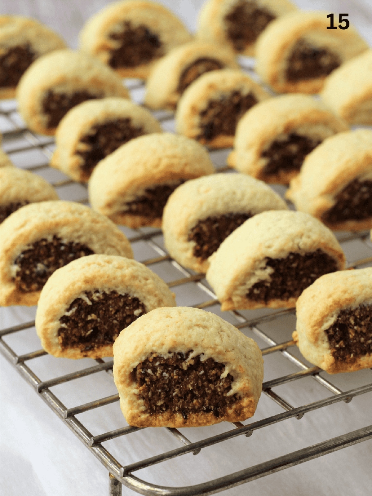 Baked cuccidati cookies on wire rack cooling.
