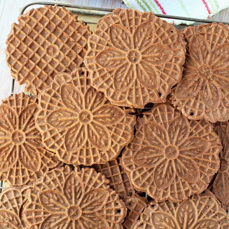 Chocolate pizzelle on wire rack.