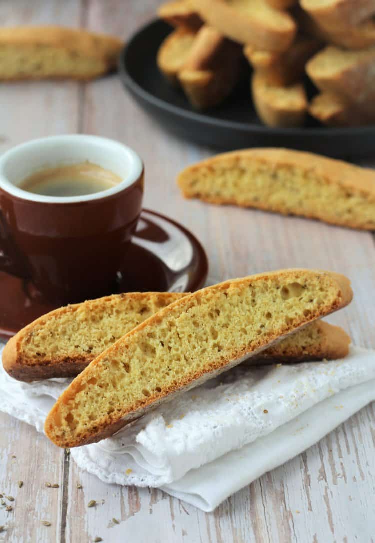 Anise biscotti next to coffee cup on napkin.