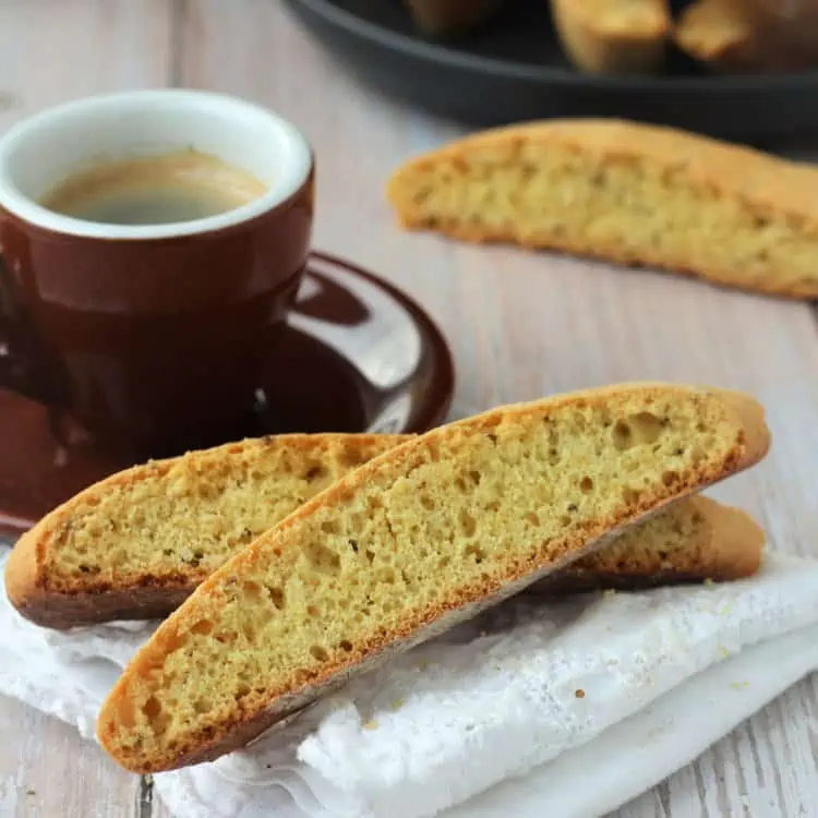 Anise biscotti resting next to coffee cup.