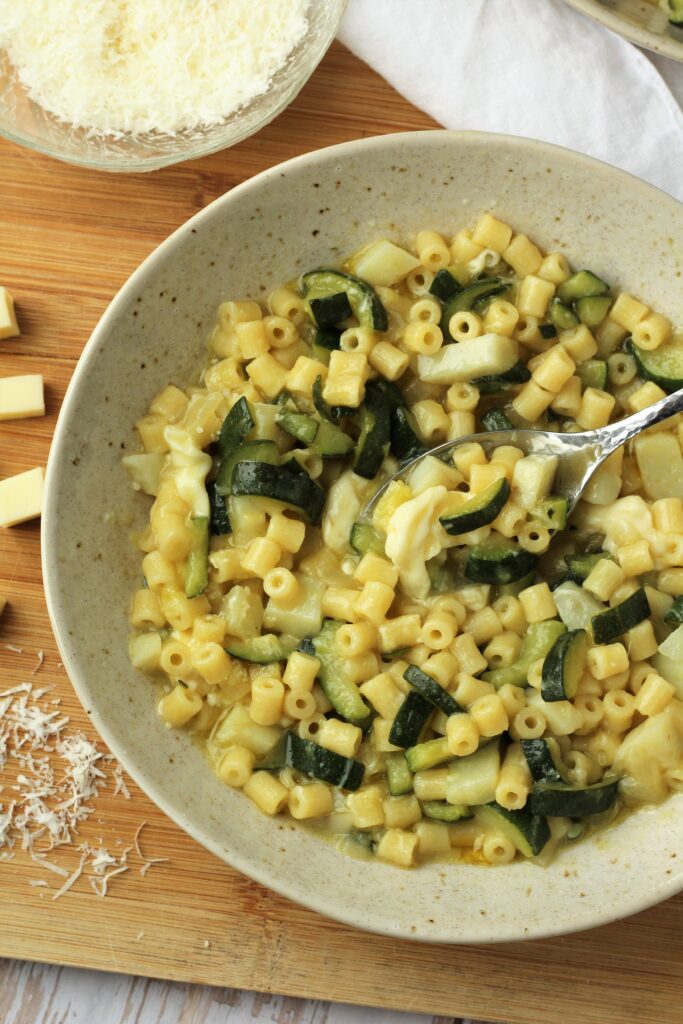 Bowl of pasta risotto with zucchini and cheese.