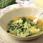 Bowl of Italian chicory soup with eggs and cheese.