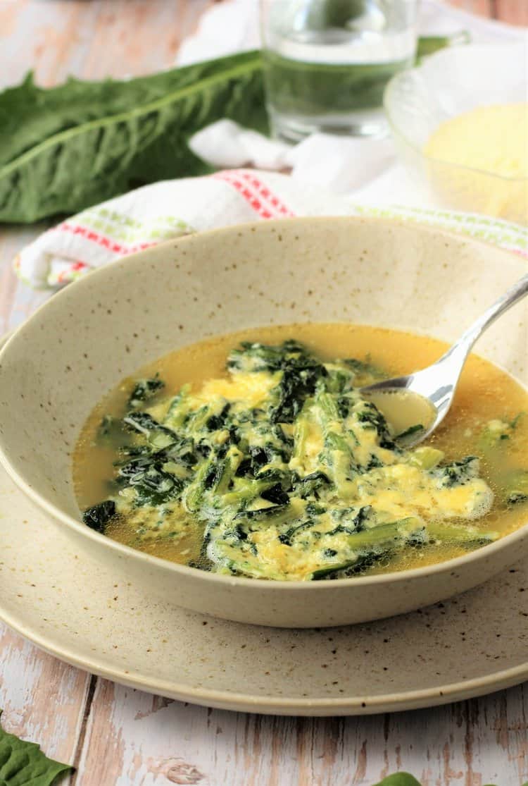 Bowl of Italian chicory soup with eggs and cheese.