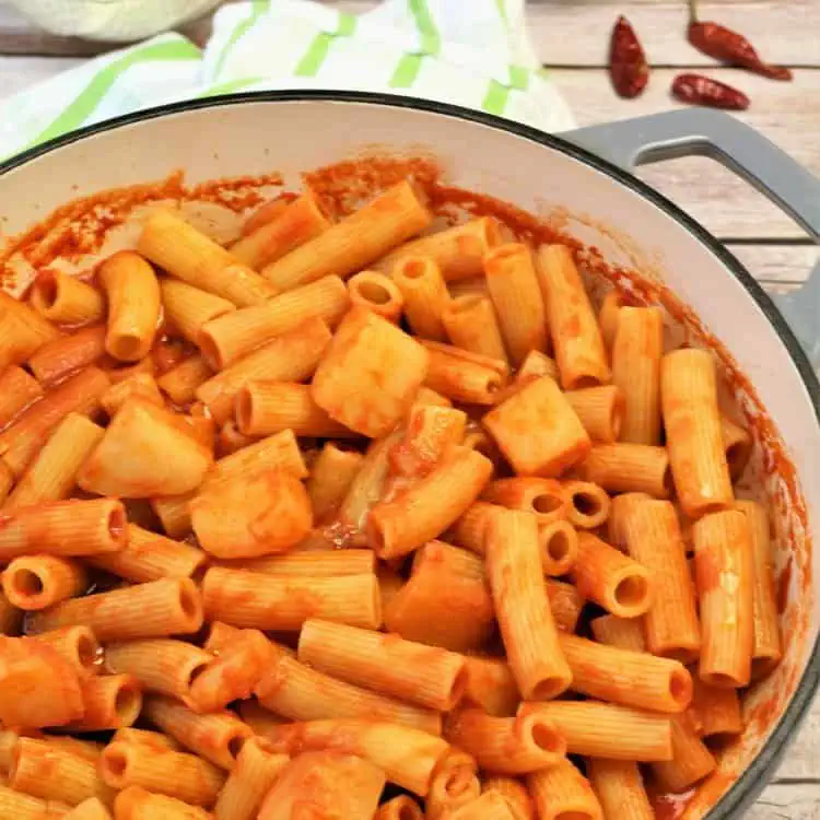 Skillet filled with pasta with potatoes in tomato sauce.