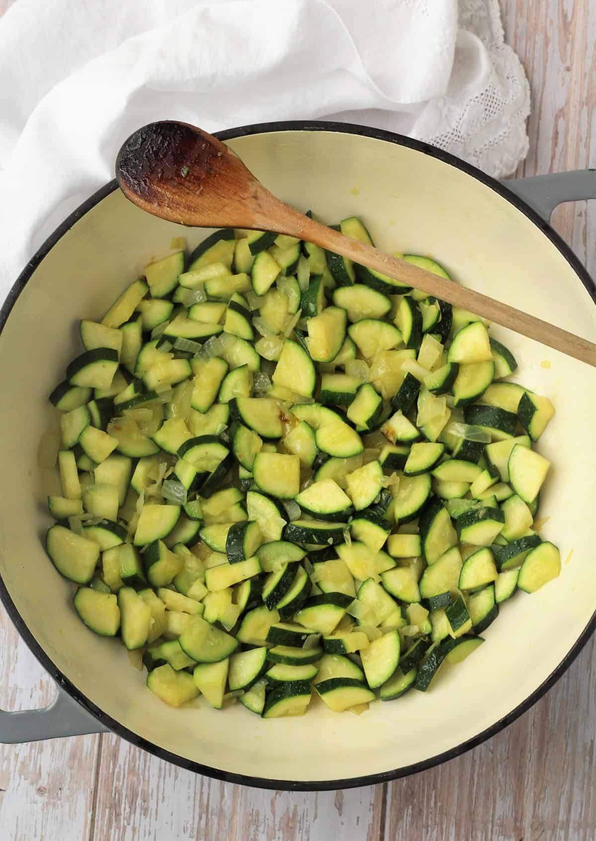 Sautéed zucchini with onion in skillet.