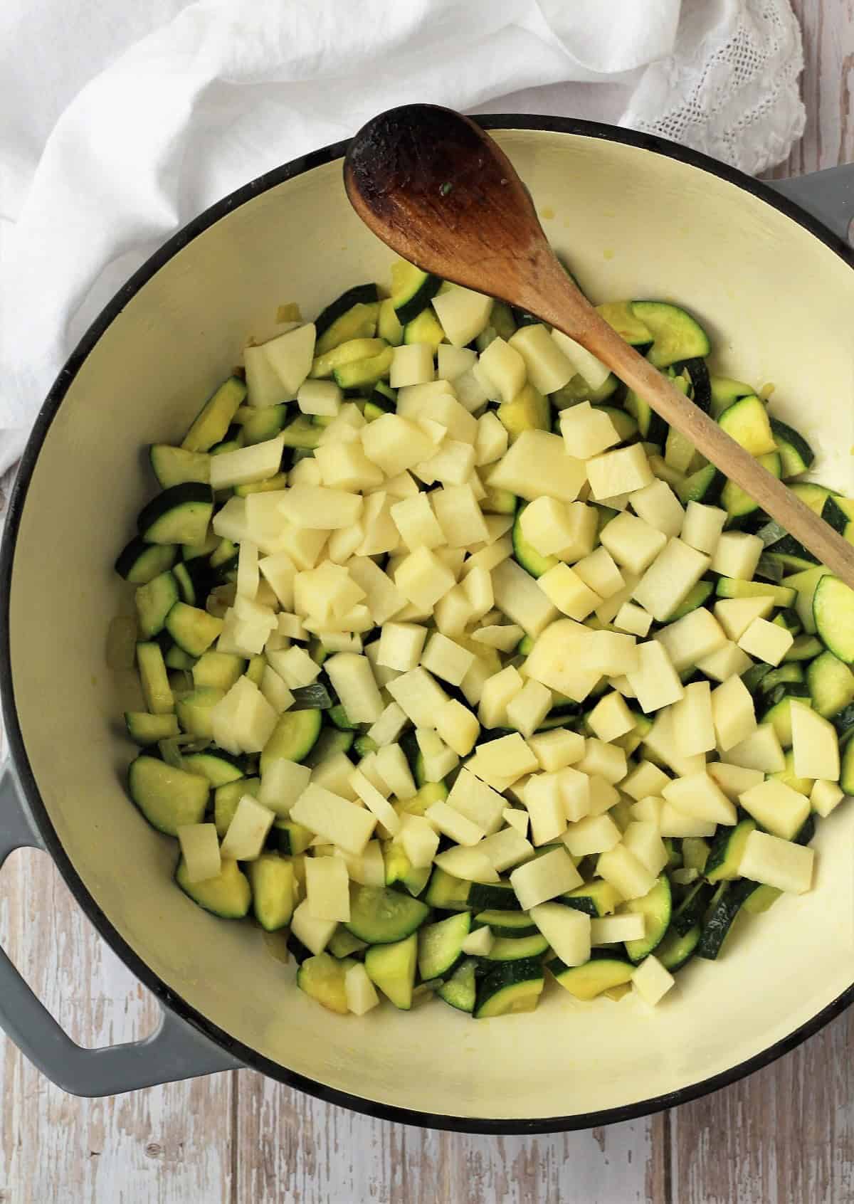 Cubed potatoes added to skillet with sautéed zucchini.