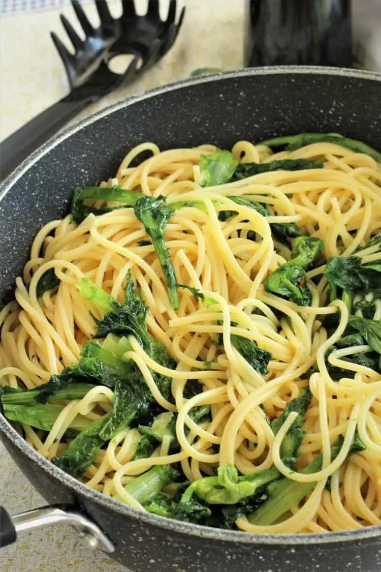 Spaghetti with escarole in large skillet with spaghetti scoop.