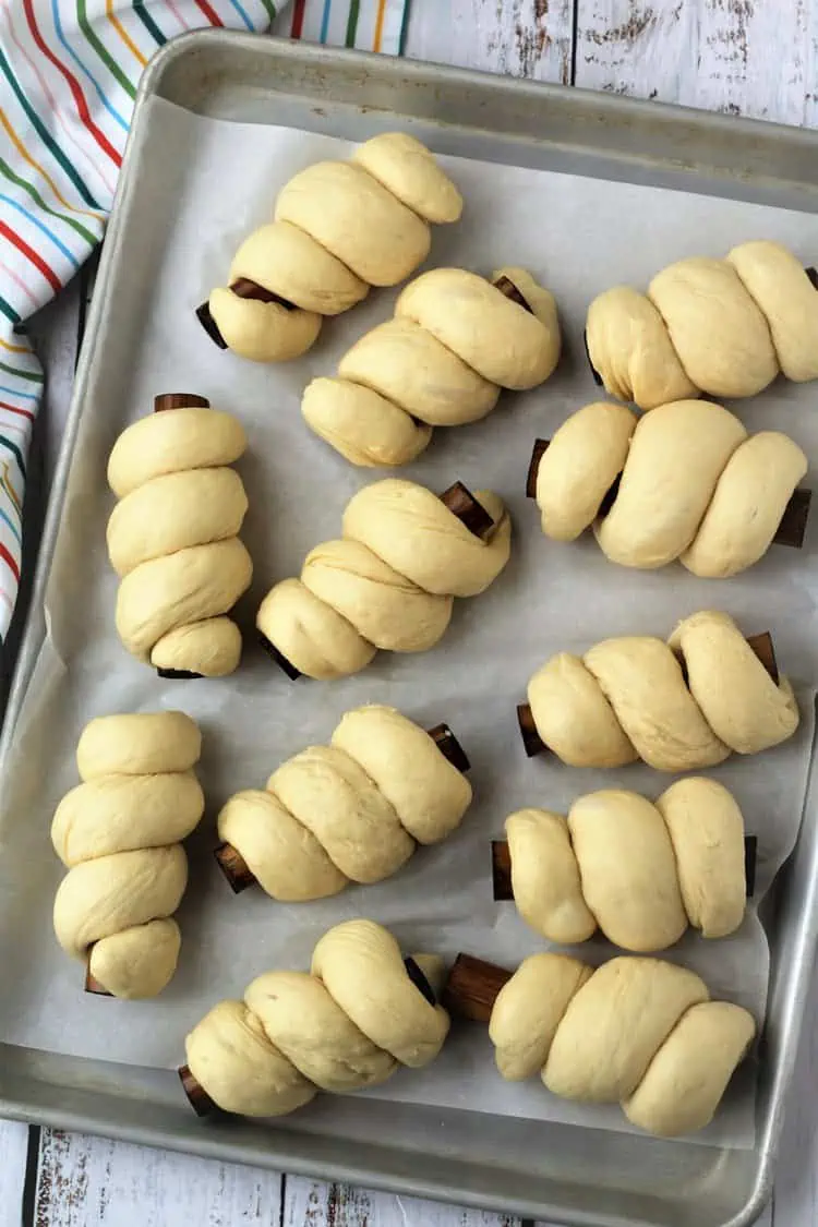 Doughnut dough wrapped around cannoli forms.