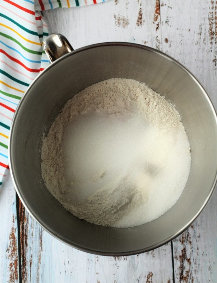 Stand mixer bowl with flour and sugar.