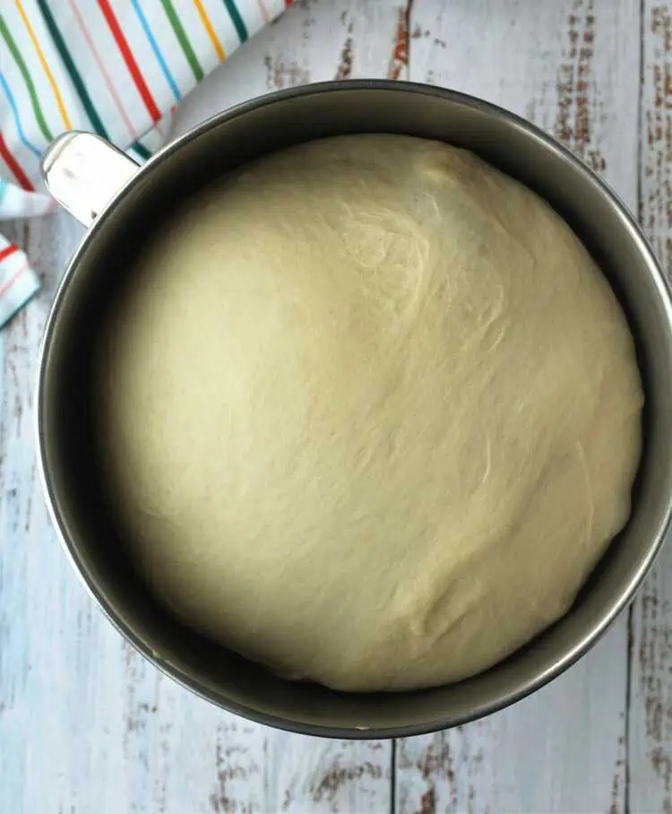 Proofed brioche sugar twist dough in stand mixer bowl.