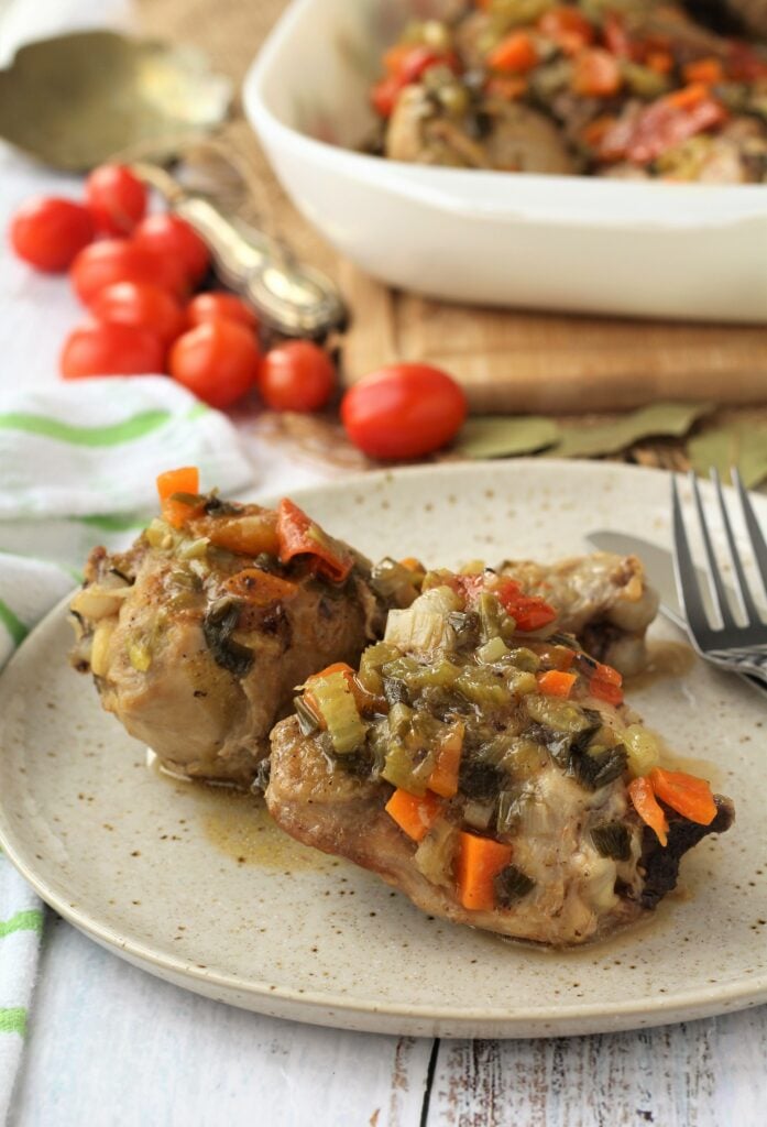 Pieces of pollo in agrodolce sauce on plate with fork.