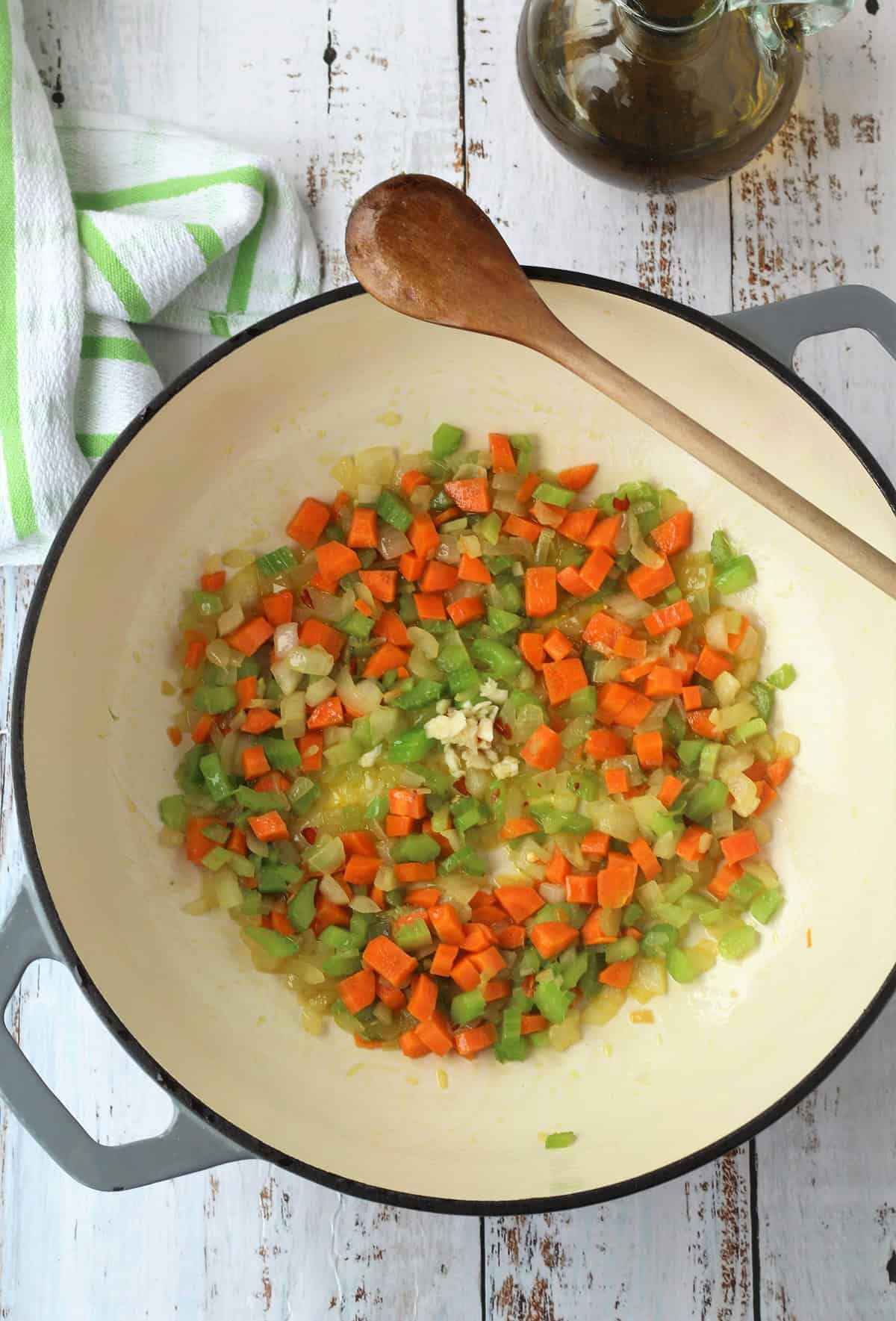 Carrot, celery and onion sautéed in skillet for chickpea pasta recipe.