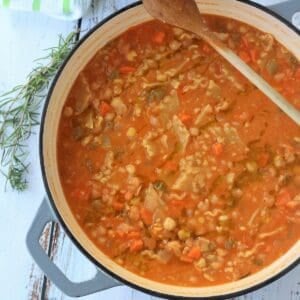 Creamy chickpea pasta in pan with wooden spoon.