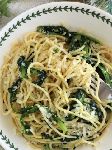 Bowl with spaghetti aglio e olio with escarole and fork.