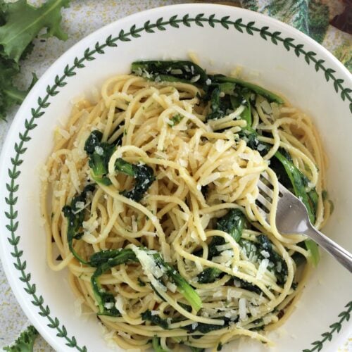 Bowl with spaghetti aglio e olio with escarole and fork.