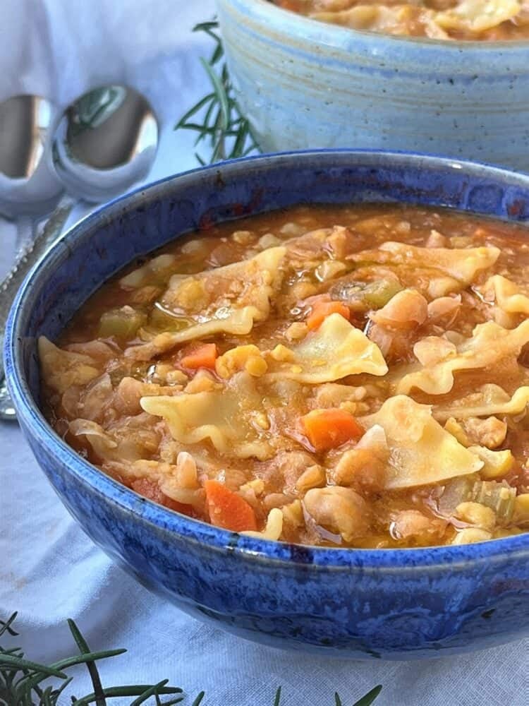 Creamy chickpeas with pasta soup in blue bowl.