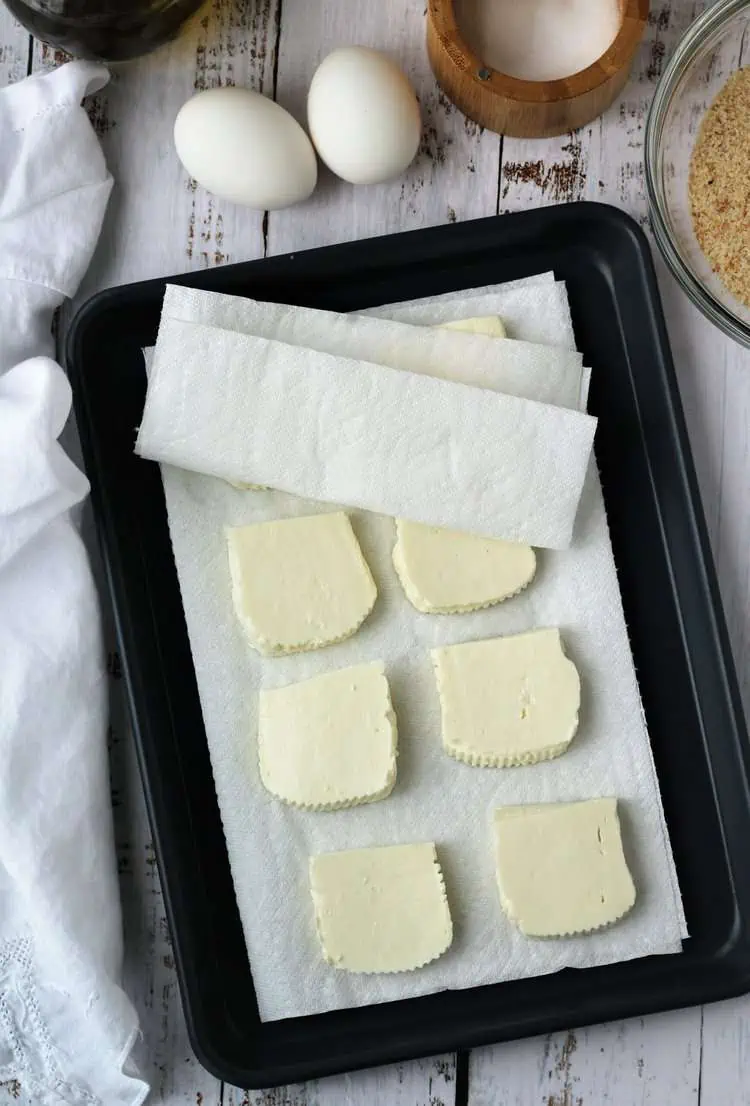 Tuma cheese squares on paper towel lined baking sheet.