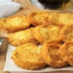 Breaded fried tuma cheese pieces on wood board.