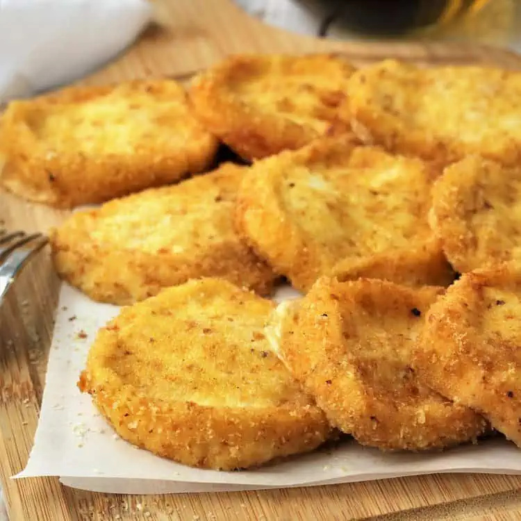 Breaded fried tuma on wood board.