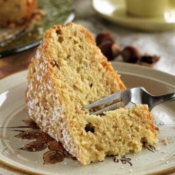 Fork cutting into slice of hazelnut cake.