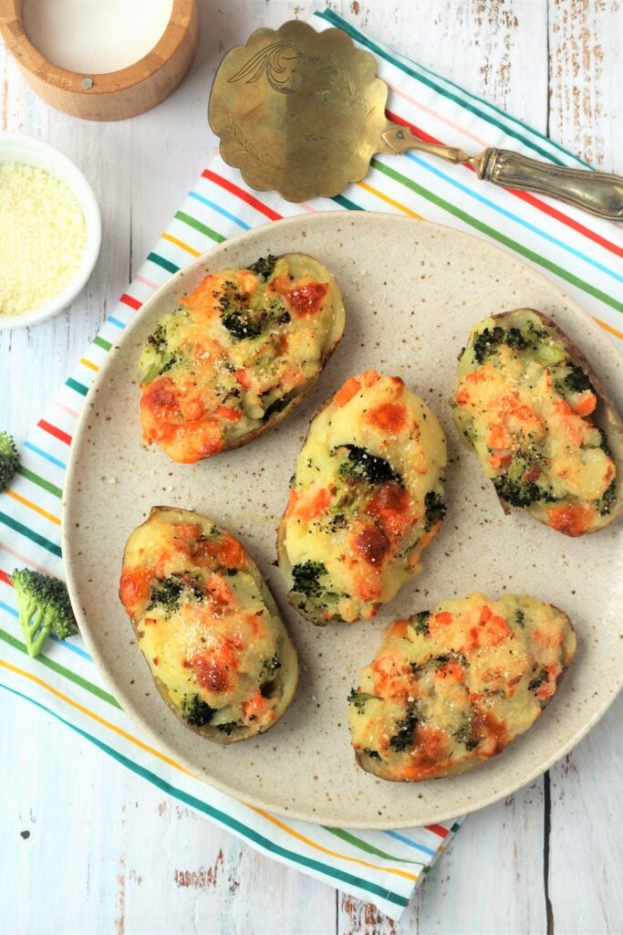Broccoli, carrot and cheese baked potatoes on plate.