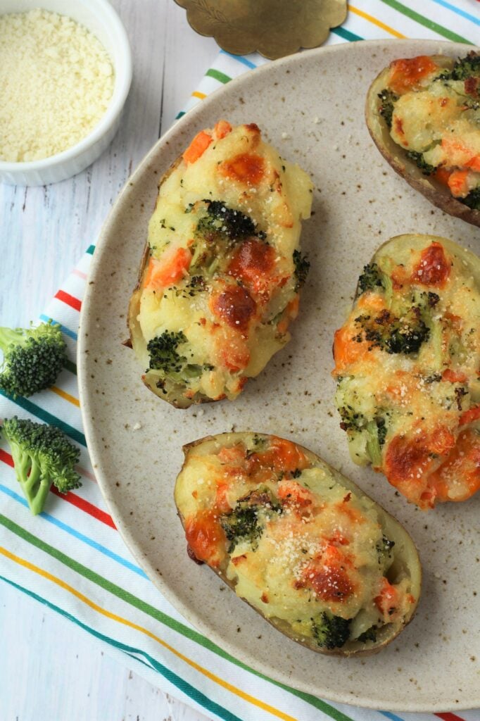 Broccoli, carrot and cheese baked stuffed potatoes on plate.