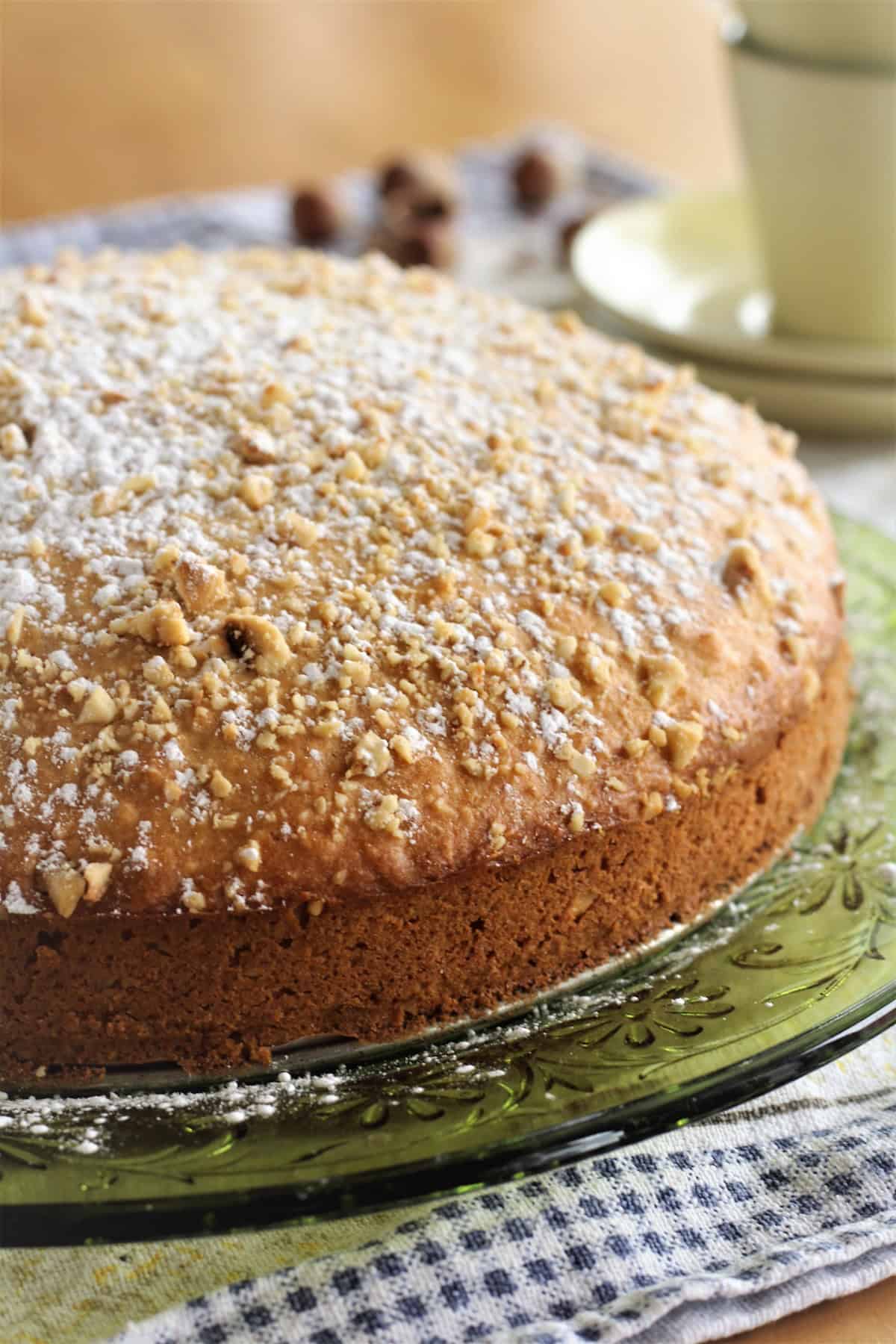 Sicilian hazelnut cake on green plate dusted with powdered sugar.