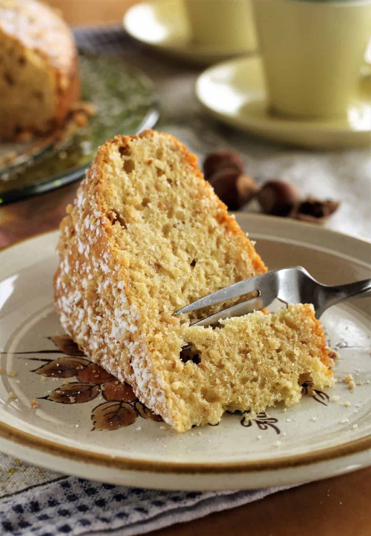 Slice of Sicilian hazelnut cake with fork cutting into it.