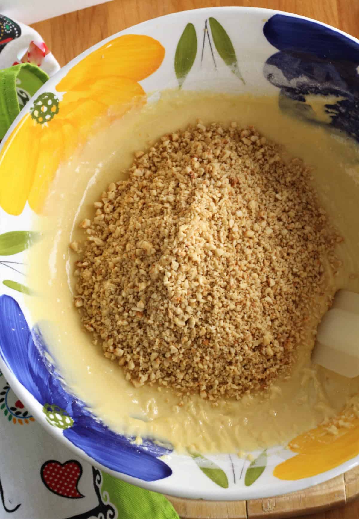 Ground hazelnuts added to bowl with eggs, sugar mixture.
