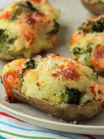 Broccoli and cheese stuffed baked potato on plate.