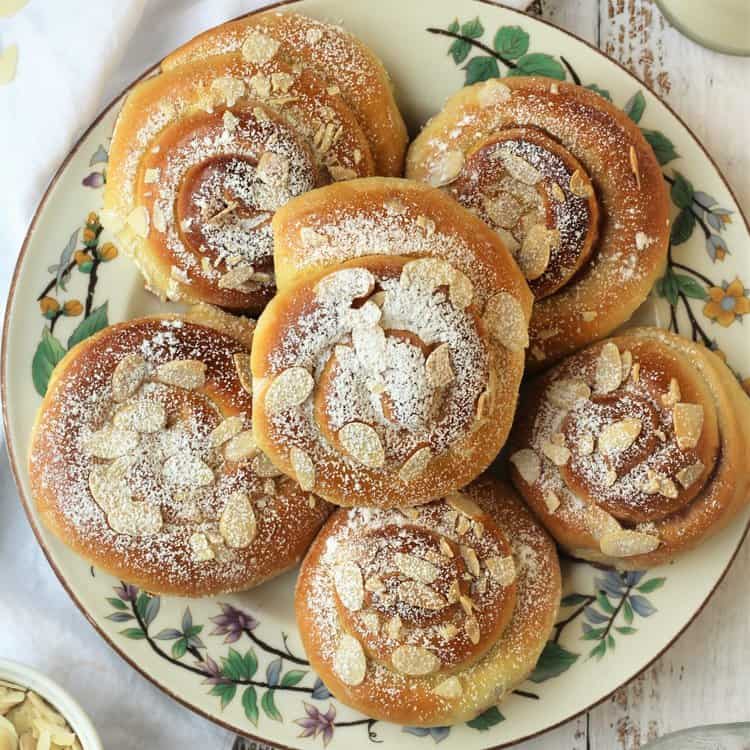 Plate of almond topped brioche swirls.