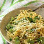 Plate of spaghetti with fava beans and peas with grated cheese.