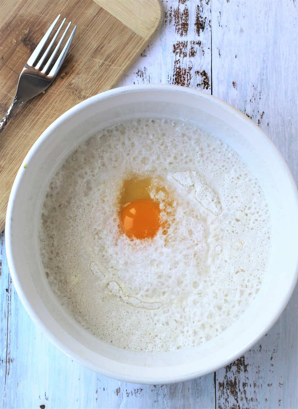 Flour, salt and egg in bowl for zucchini fritter batter.