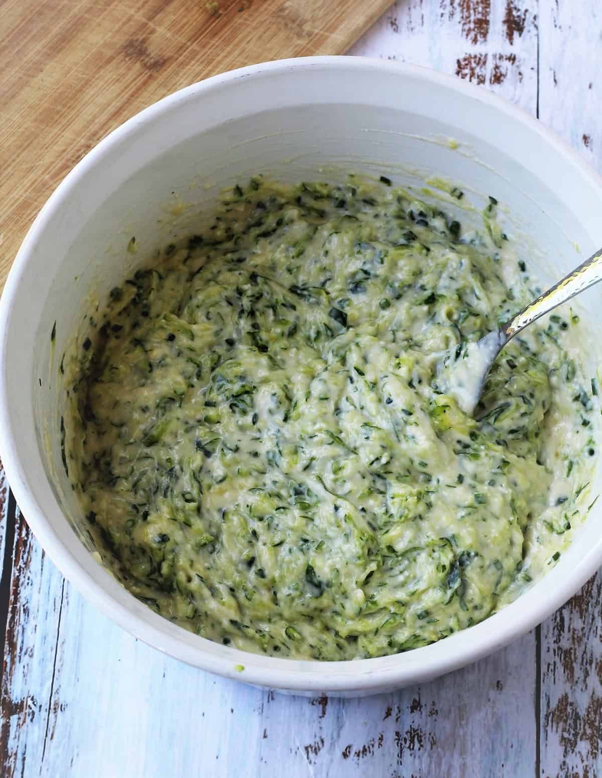 Italian zucchini fritters batter in large bowl with fork.