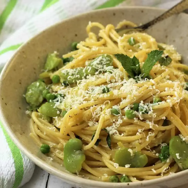 Bowl of spaghetti with fava beans and peas.