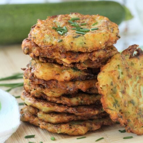 Piled Italian zucchini fritters topped with chives.