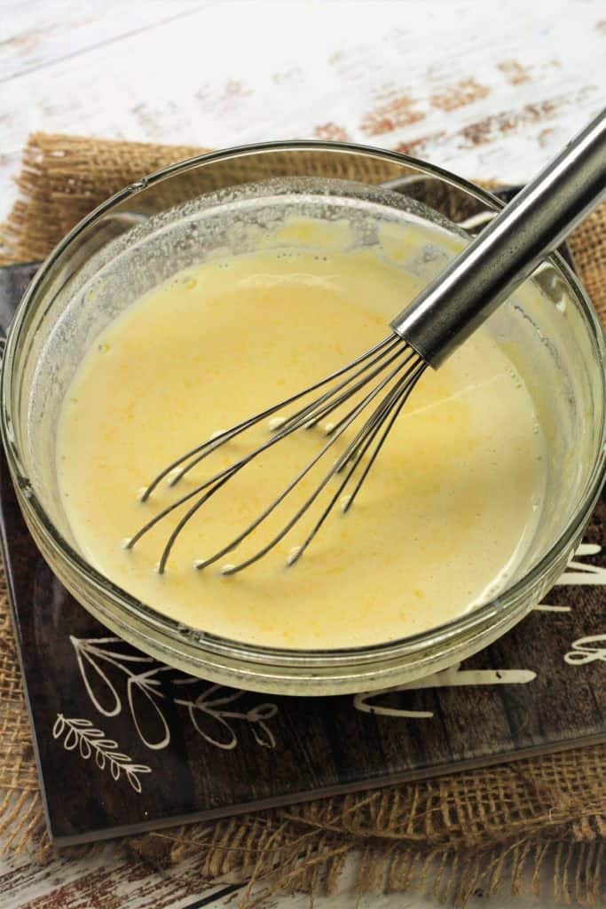 Tempering eggs with warmed milk with whisk.