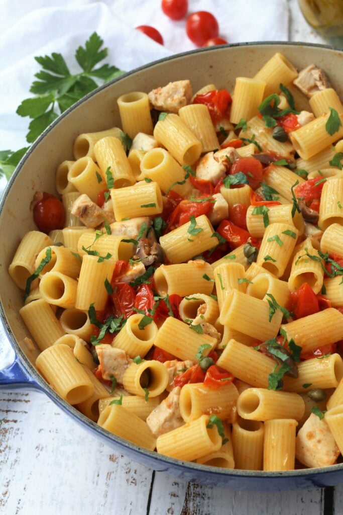 Skillet filled with swordfish pasta with capers and olives.