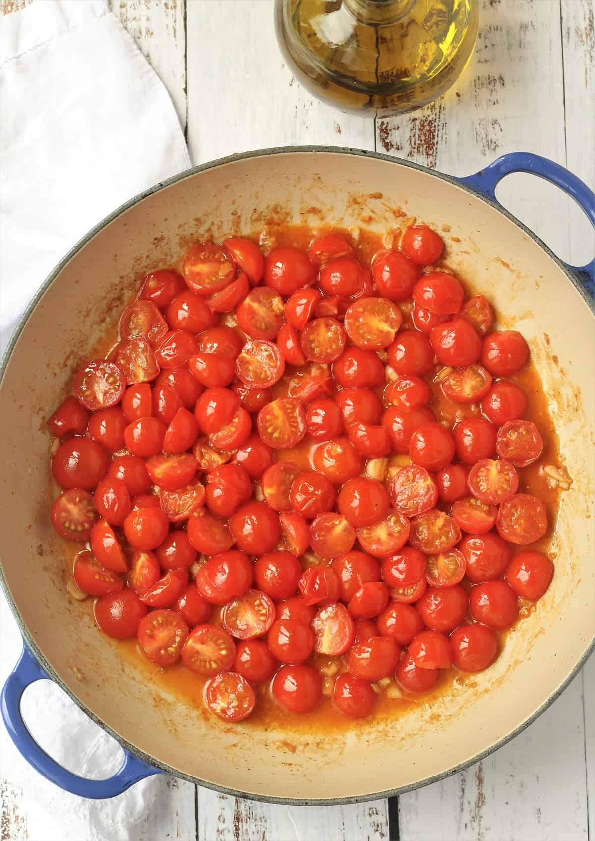 Blistered cherry tomatoes in large skillet with olive oil.