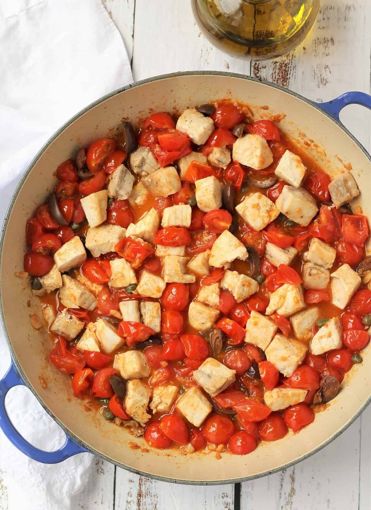 Swordfish, cherry tomato. olive and caper pasta sauce in large skillet.