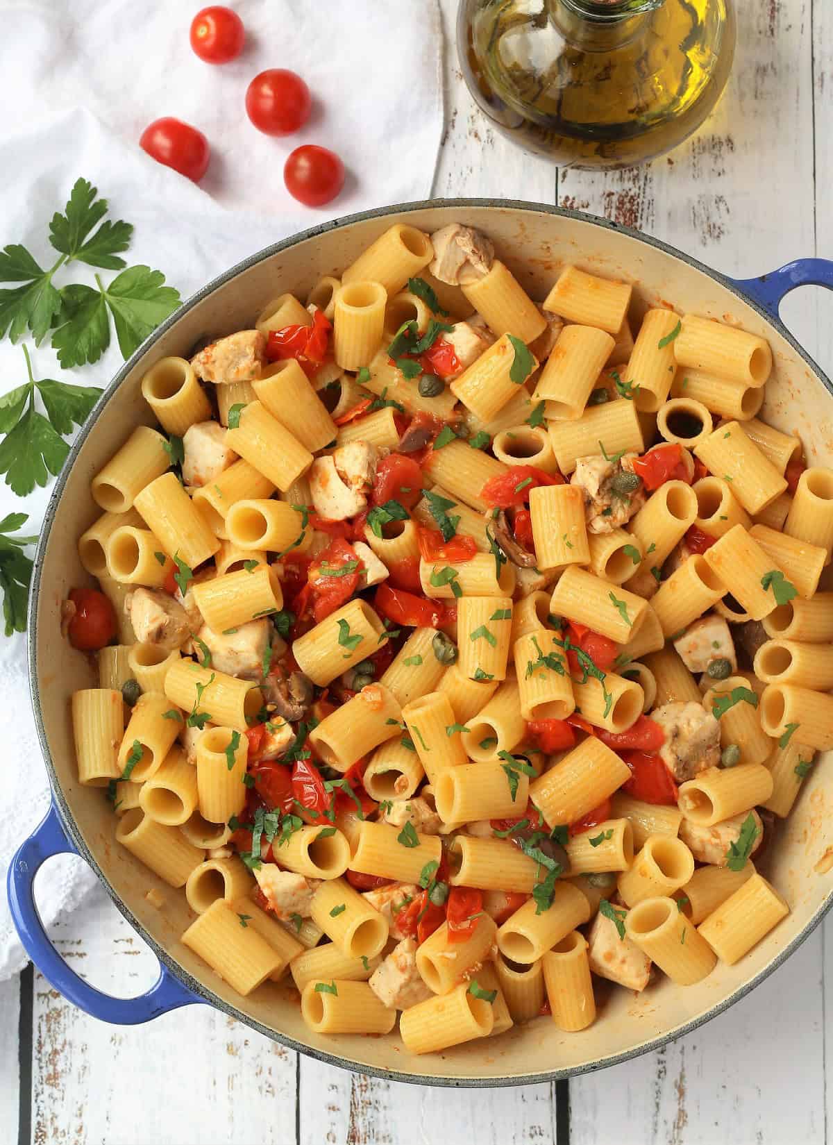 Pasta with swordfish and cherry tomato sauce in large blue skillet.