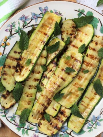 Italian grilled zucchini with mint and vinegar on plate.