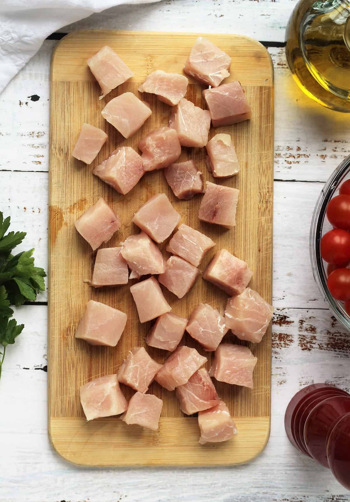 Cubed swordfish on wood board for swordfish pasta recipe.