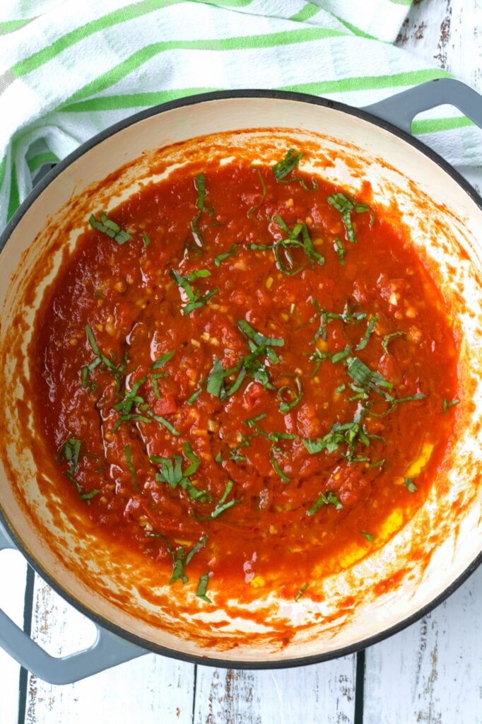 Fresh tomato sauce topped with basil in large skillet.