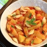 Cucuzza with tomatoes, potatoes and pasta in bowl with basil.